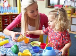 طفلة صغيرة ومشرفة في مركز الرعاية في ألمانيا اوسبيلدونغ رعاية الأطفال في المانيا