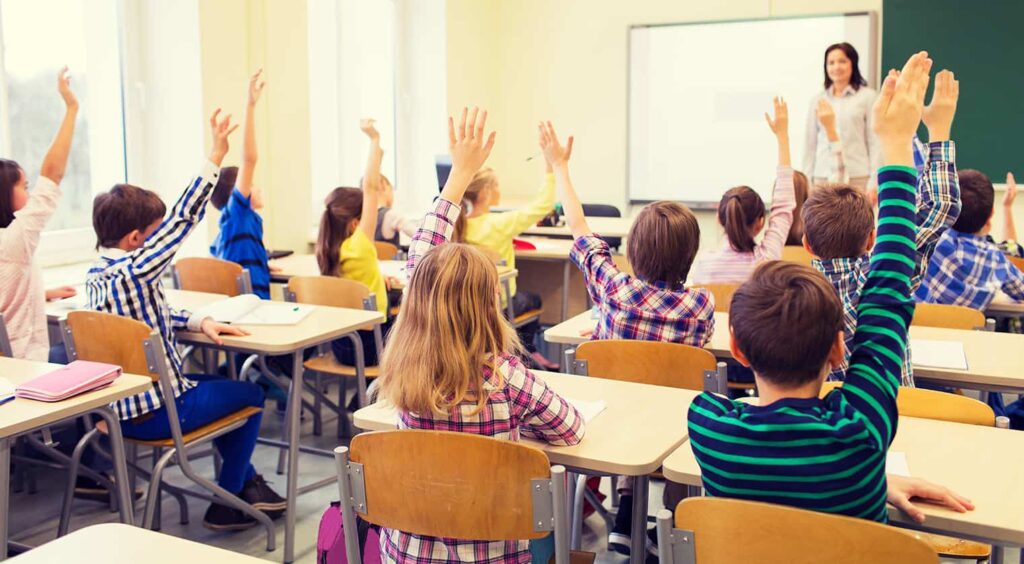 إحدى الصفوف يتواجد فيه الطلاب والمعلمة التي تقوم بأداء دورها الوظيفي